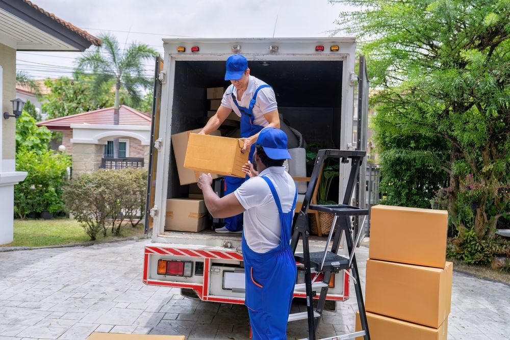 Two Men Are Loading Boxes Into a Moving Truck — Ocean Grove Removals In Bendigo, VIC