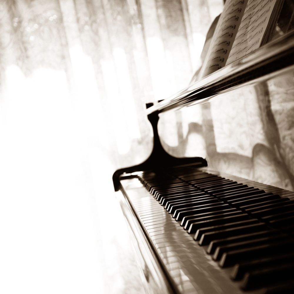 A Black and White Photo of a Piano With Sheet Music on It — Ocean Grove Removals In Whittington, VIC 