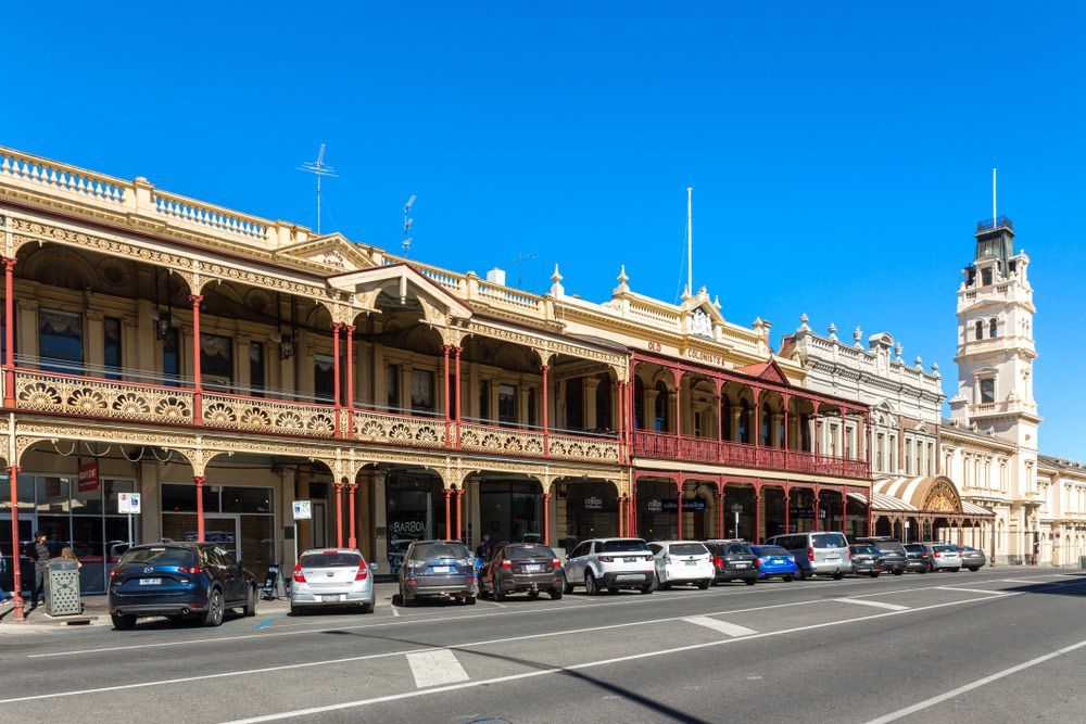 A Row of Cars Are Parked in Front of a Large Building — Ocean Grove Removals In Ballarat, VIC