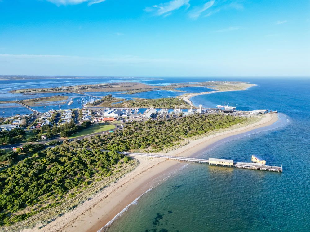 An Aerial View of a Beach With a Pier and a City in the Distance — Ocean Grove Removals In Bellarine Peninsula, VIC