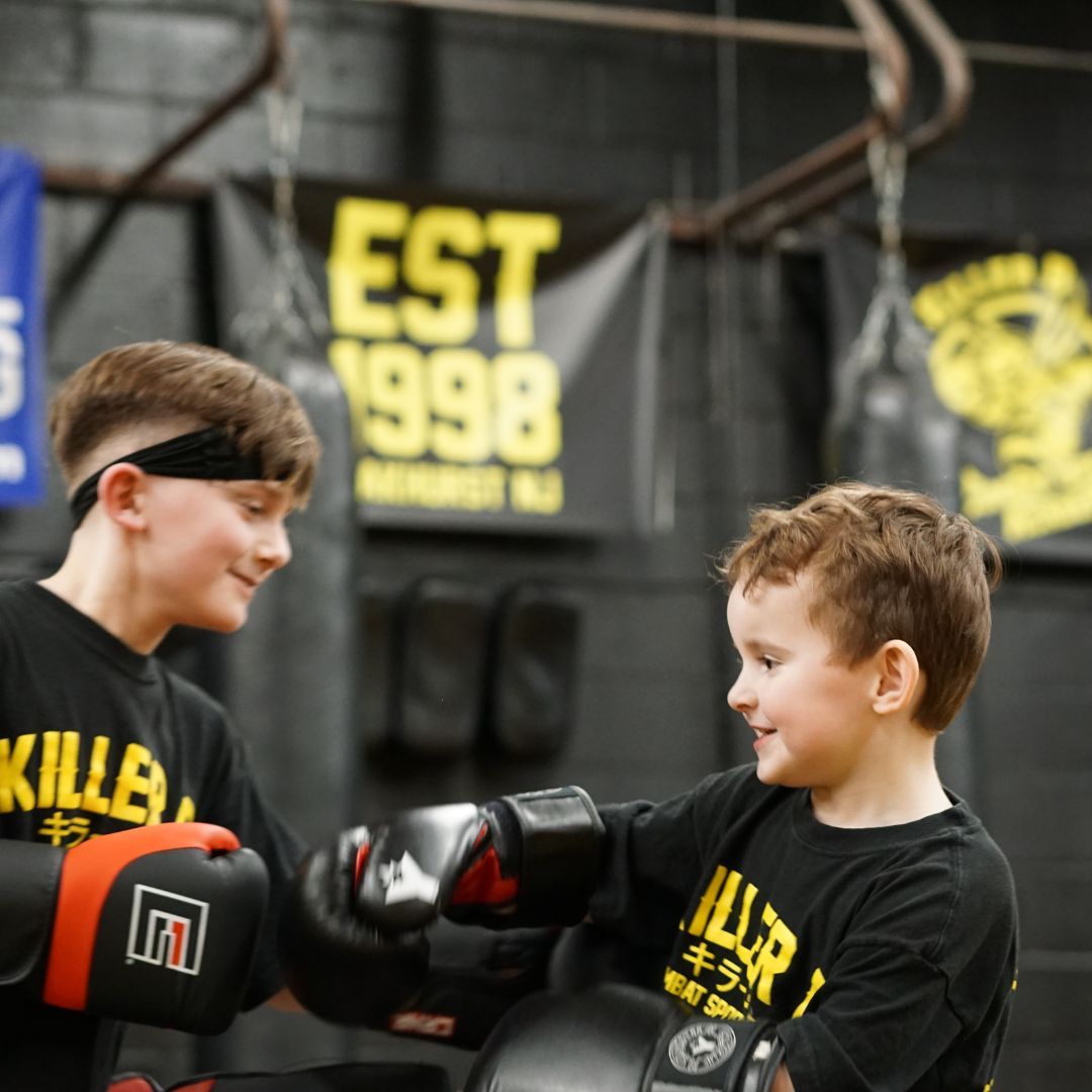 Kids practice partner drills at Killer B Combat Academy in Oakhurst, NJ, building confidence, respect, and teamwork.