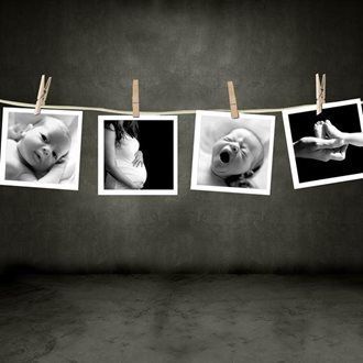 Four black and white photos clipped to a string: baby, pregnant belly, baby, hands holding a tiny foot.