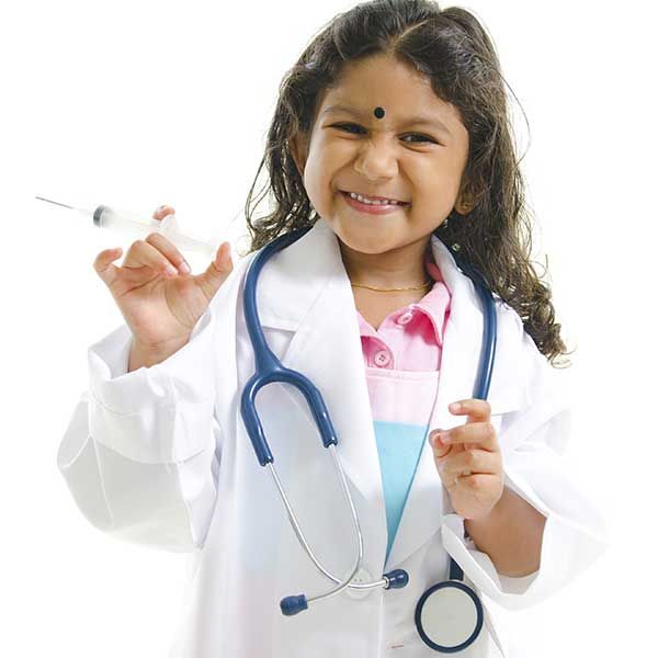 Child in a doctor's coat and stethoscope smiling, holding a syringe.