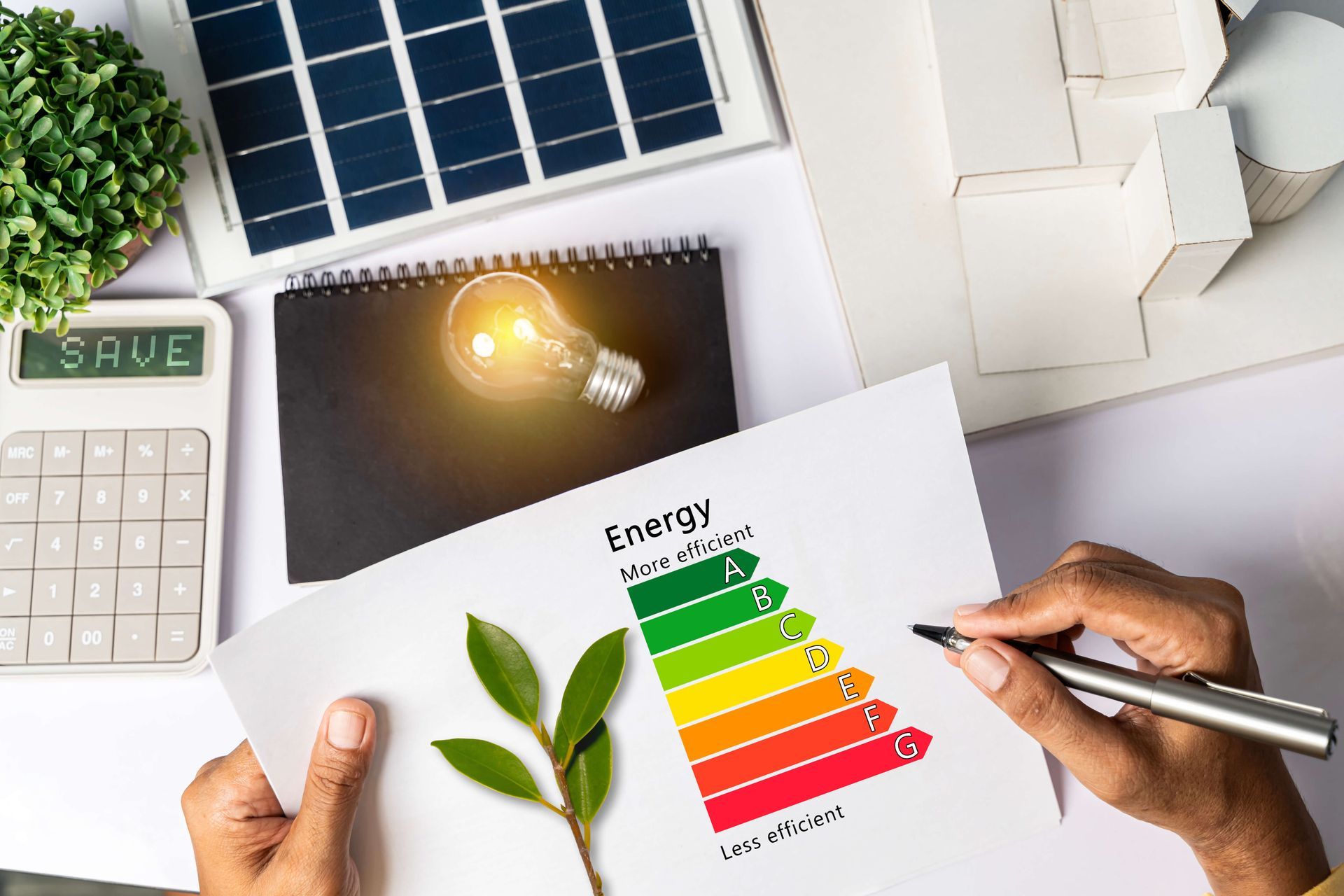 Une personne écrit sur un morceau de papier avec un tableau d'efficacité énergétique dessus.