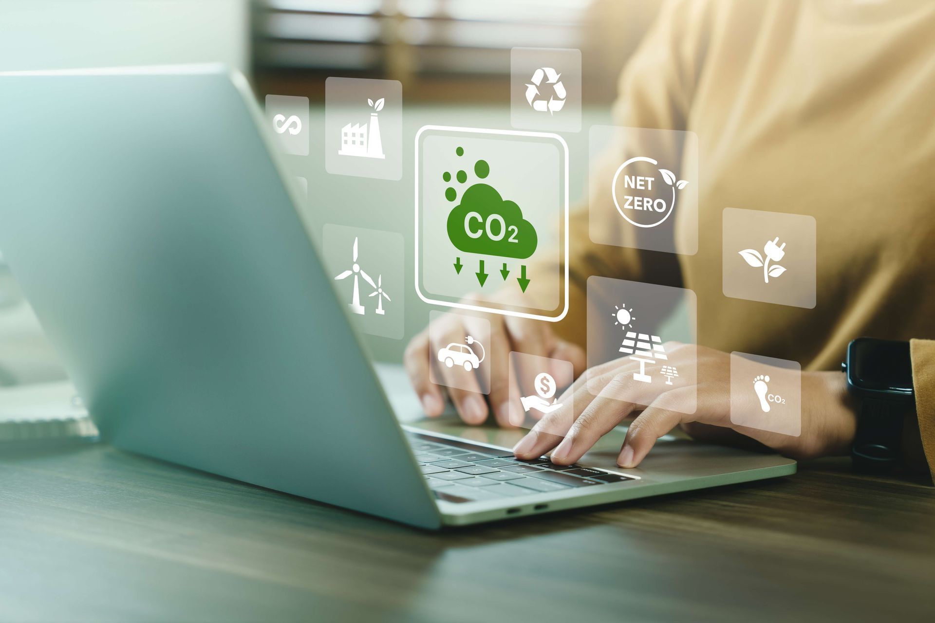 Une personne tape sur un ordinateur portable avec une icône de CO2 sur l'écran.