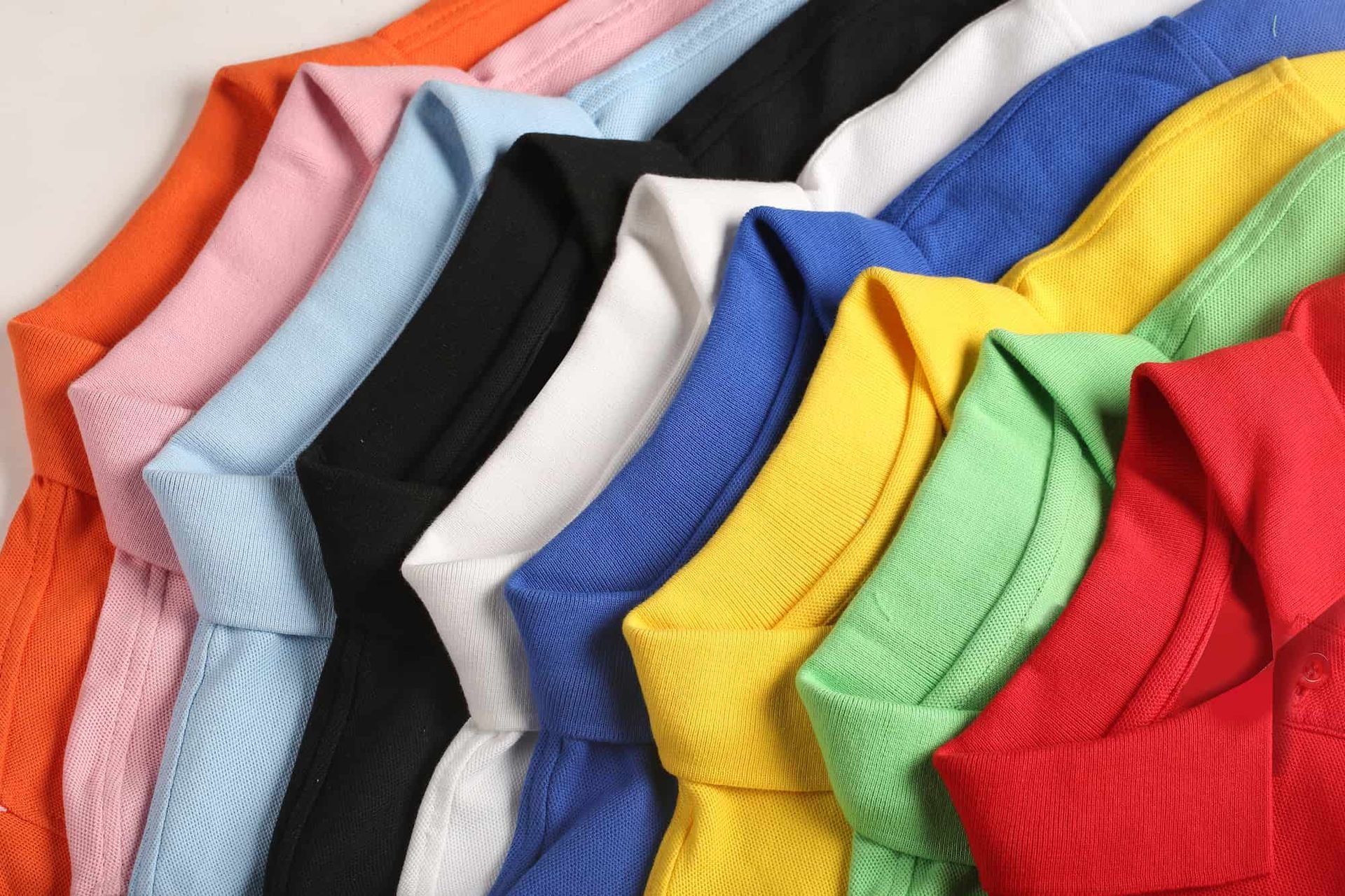 Close-up of a stack of folded, colorful t-shirts in various colors.