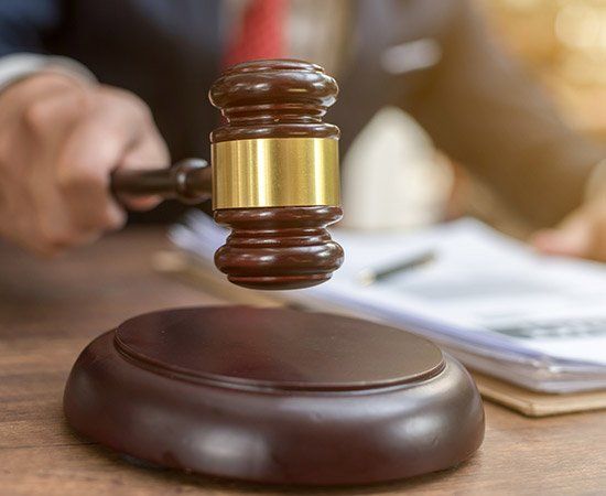 Lawyer Holding Gavel — Lake City, FL — Lloyd E. Peterson Jr., Sandra H. Peterson, Attorneys At Law Lawyer Holding Gavel — Lake City, FL — Lloyd E. Peterson Jr., Sandra H. Peterson, Attorneys At Law