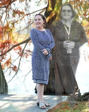 Woman in a blue patterned dress standing outdoors beside a faded ghostly figure by the water.