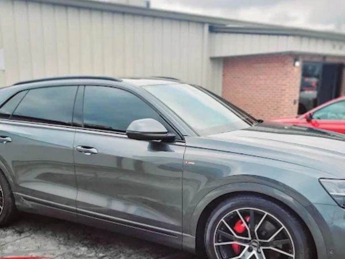 Gray Audi SQ5 parked outside showing a dark window tint across all side windows