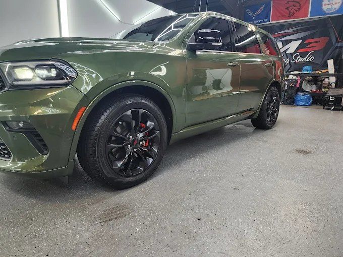 Olive green Dodge Durango SRT parked inside a shop after a ceramic coating service