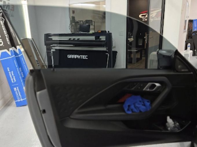 Graphtec plotter cutting window tint film inside an auto detail shop