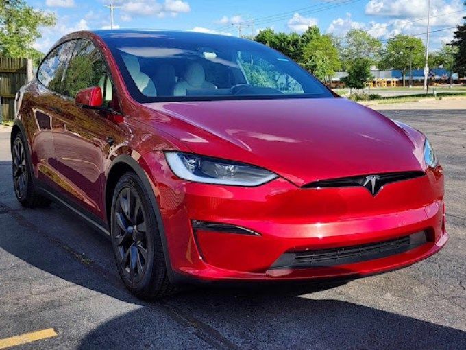Red Tesla Model X parked outdoors with a shiny ceramic coating protecting the paint