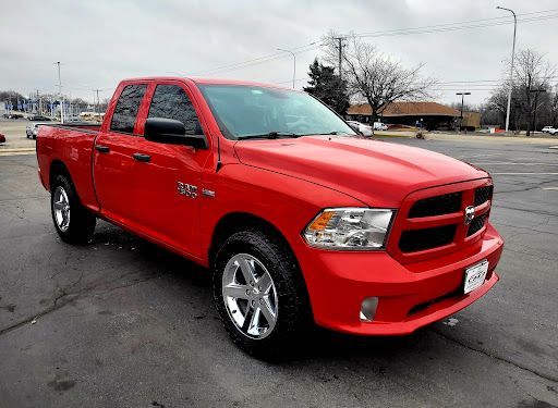 Red Dodge Ram 1500 truck with window tint on all side windows in a parking lot