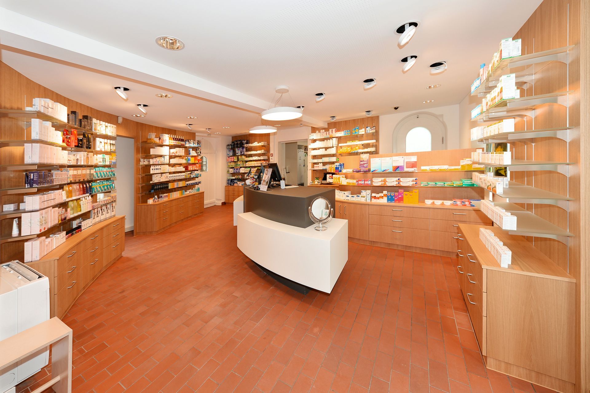 Helles Ladeninterieur mit Holzregalen, zentraler Verkaufstheke und warmer Beleuchtung