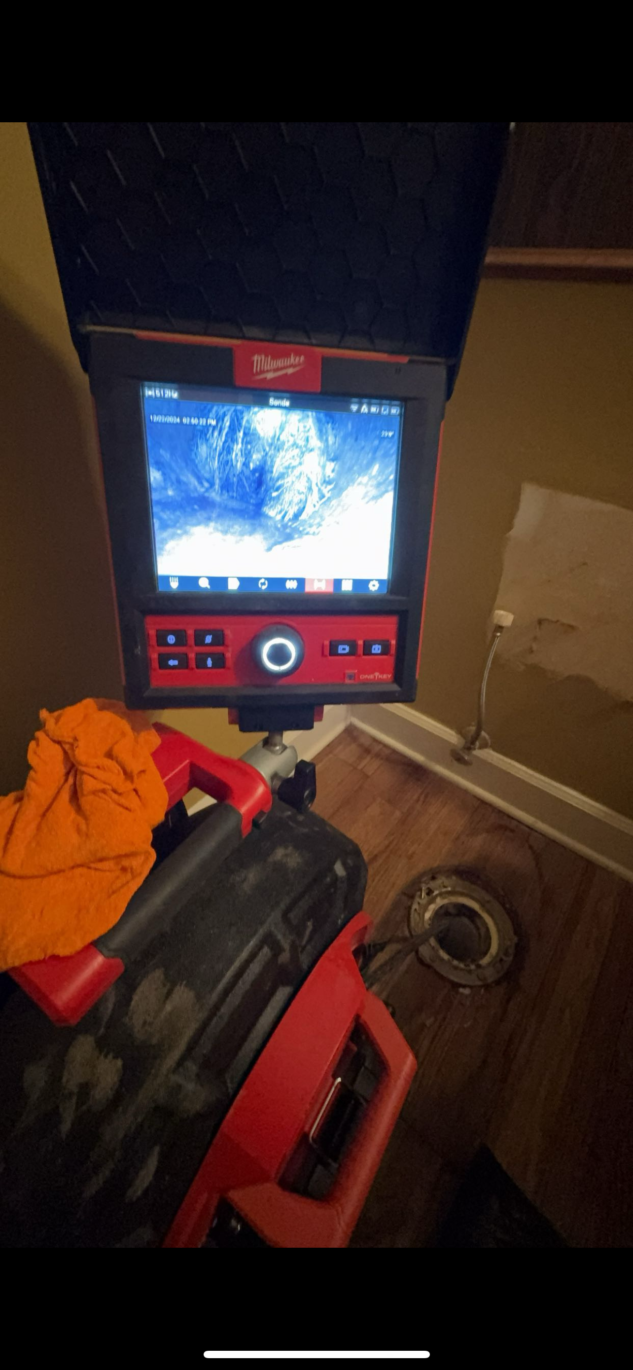 A sewer camera inspection device displaying the inside of a pipe. A plumbing job is being performed.