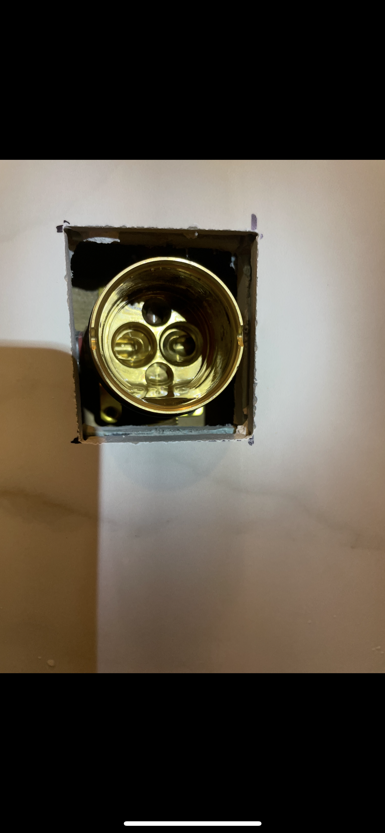 Gold-colored light fixture with an inside view of the bulb receiver.