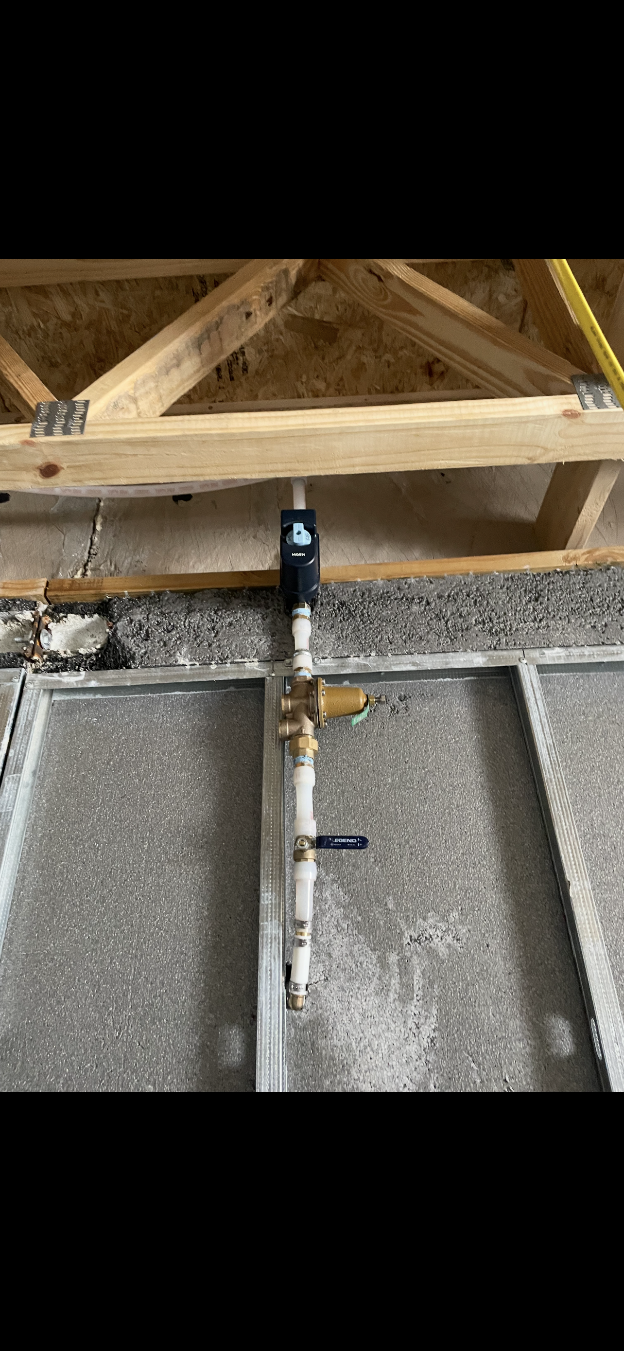 Plumbing pipes with a water meter and shut-off valve installed in a basement setting.