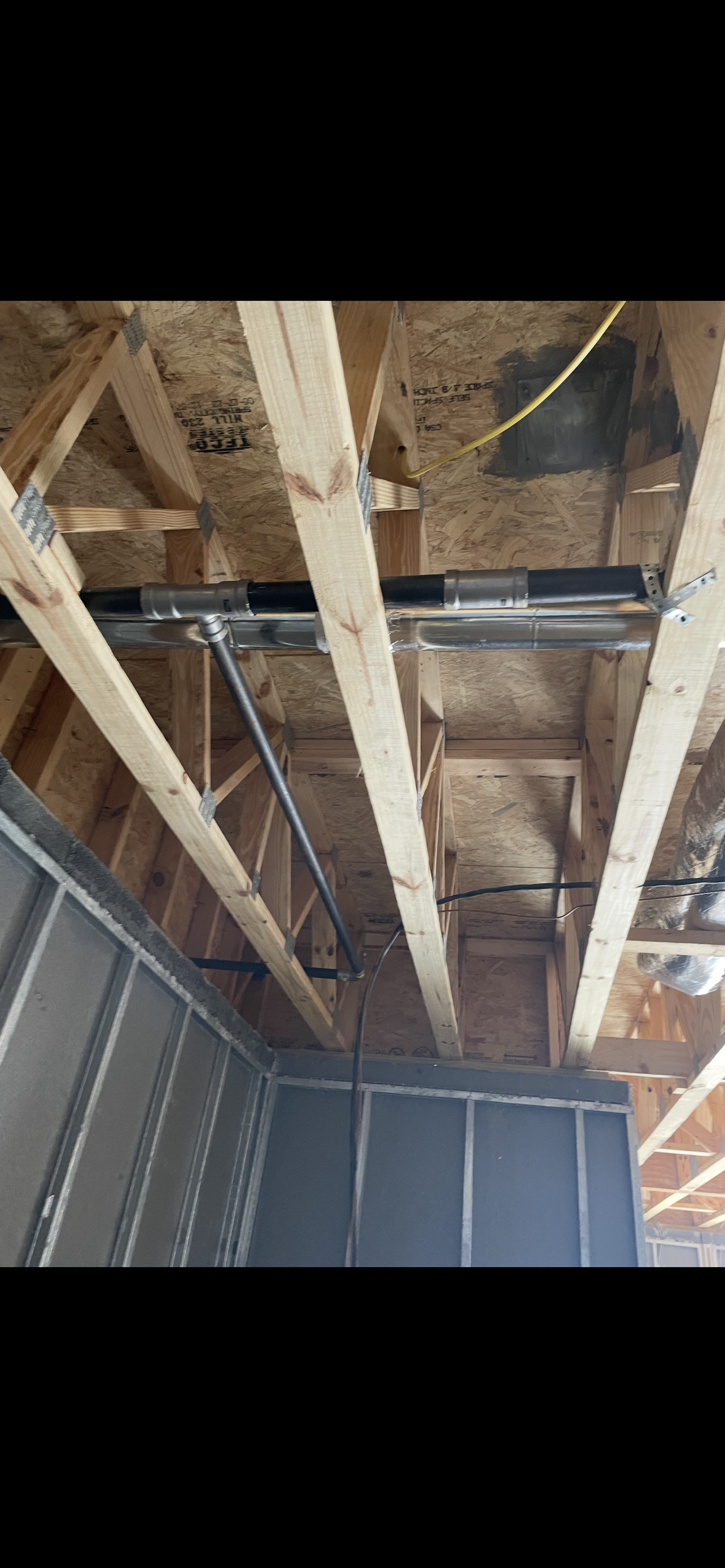 Interior view of a building under construction. Wood beams, metal framing, and insulation.