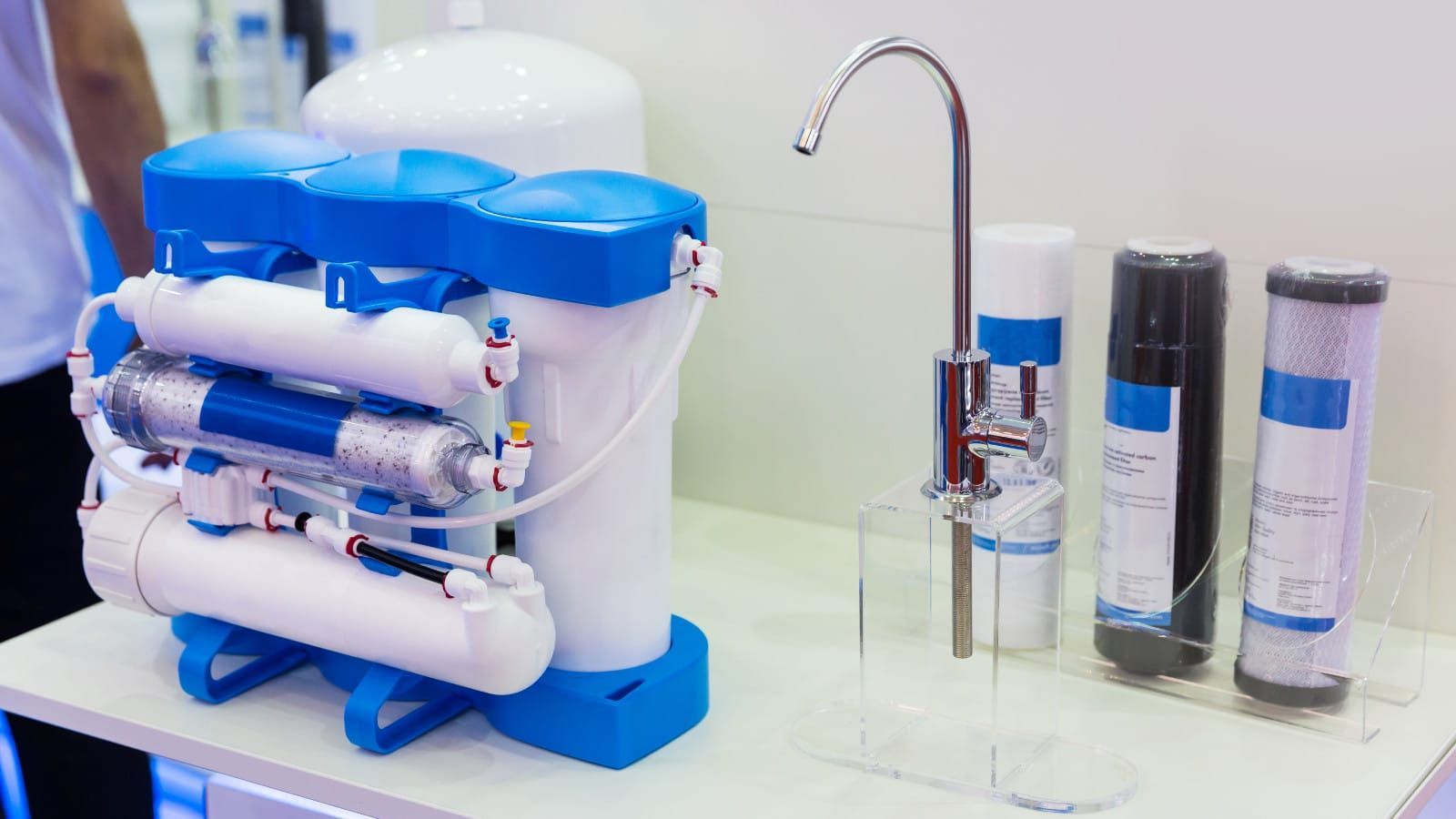 Water filtration system with blue and white components, faucet, and replacement filters.