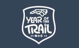 The year of the trail logo is on a blue background.