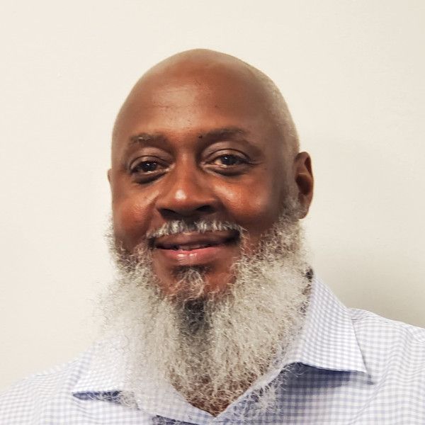 A bald man with a beard is smiling for the camera.