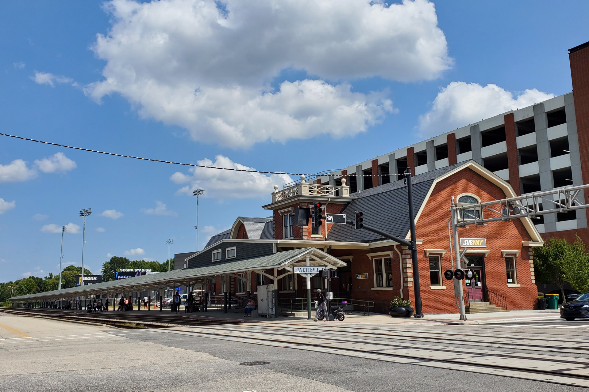 A train station with a large building in the background