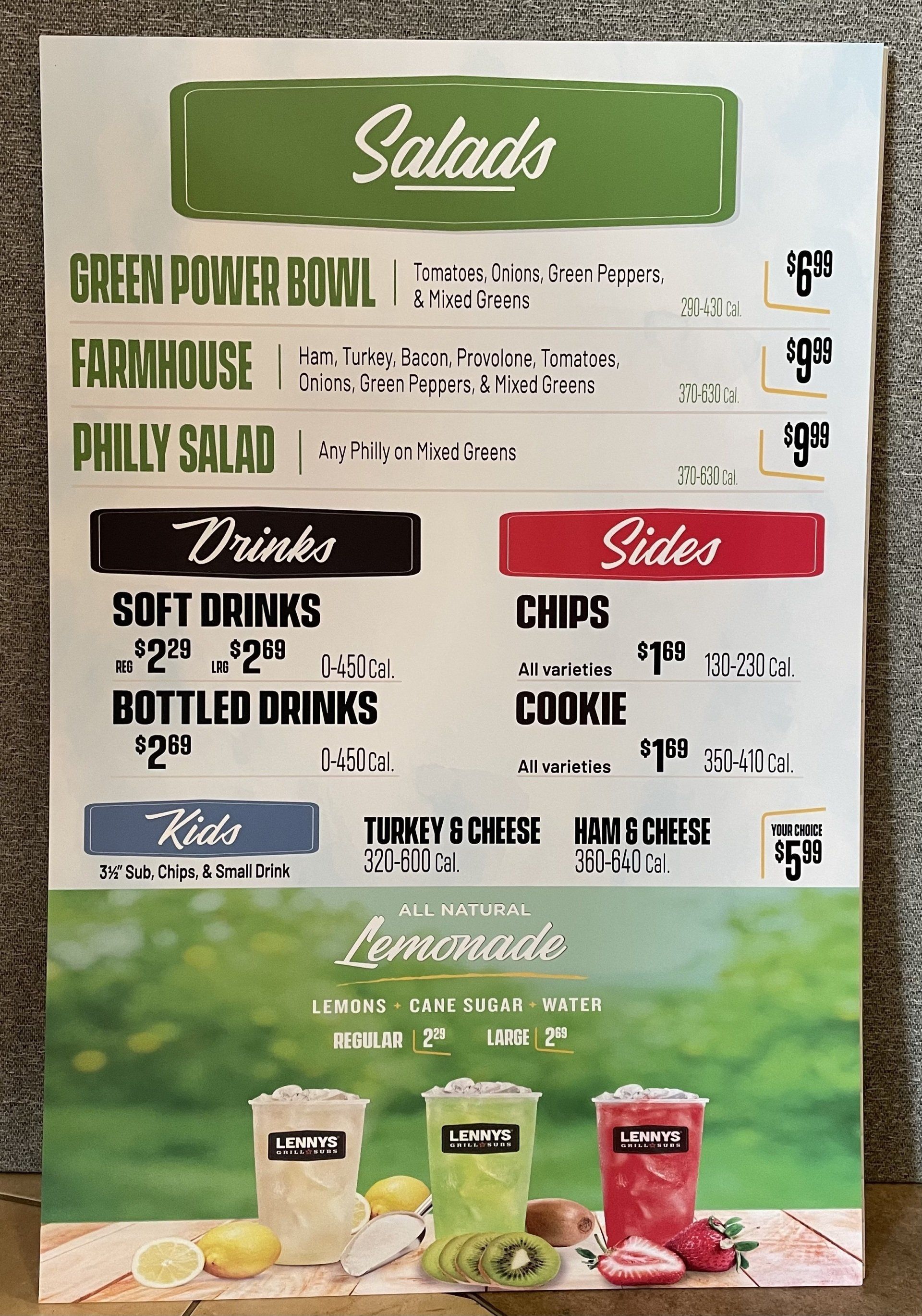 Restaurant menu with salad, drinks, sides, and kids' options; lemonade advertisement in front.