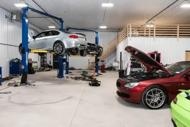 Silver car raised up with red on floor with hood up in garage | Eurocharged