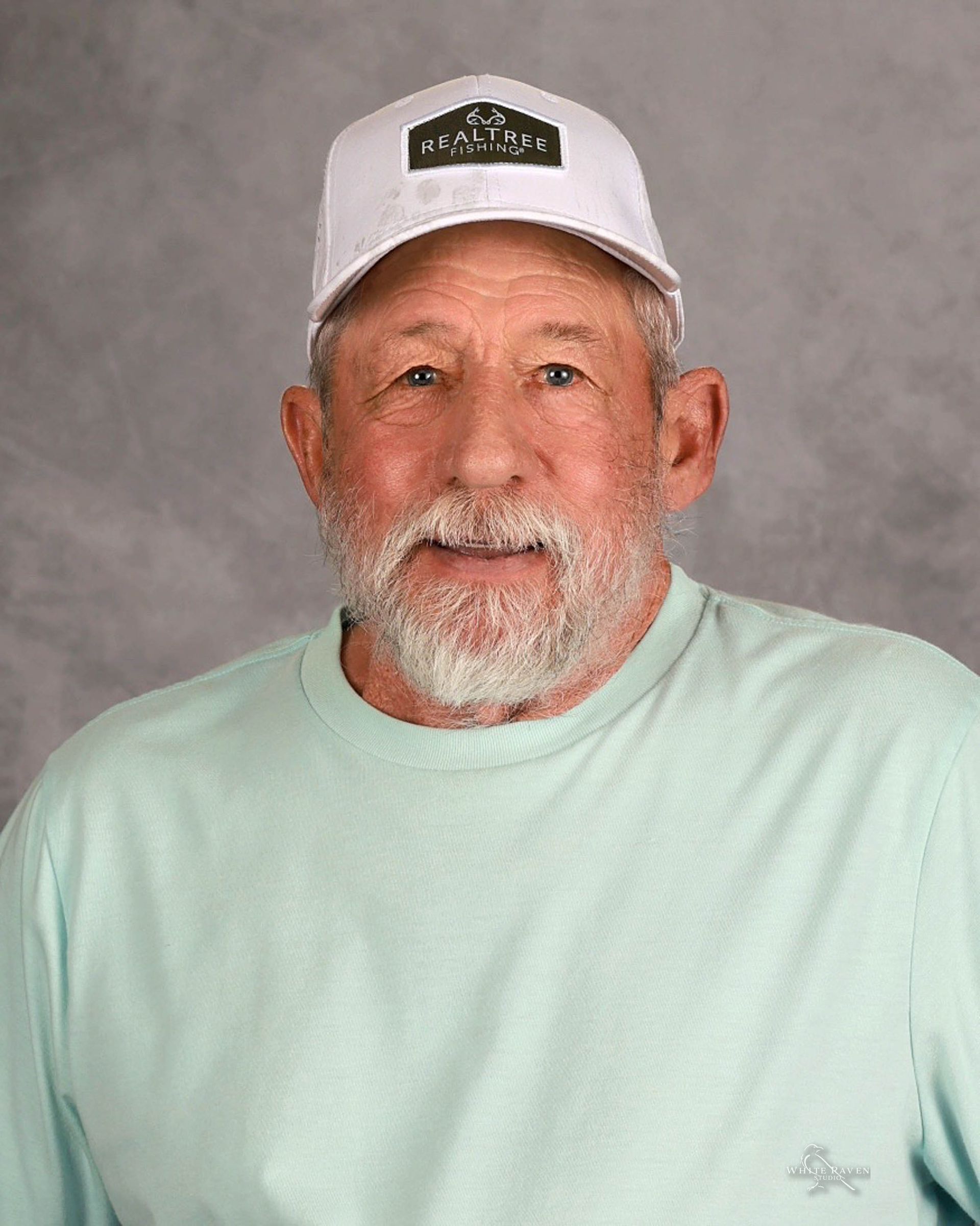 A man with a beard wearing a hat and glasses.