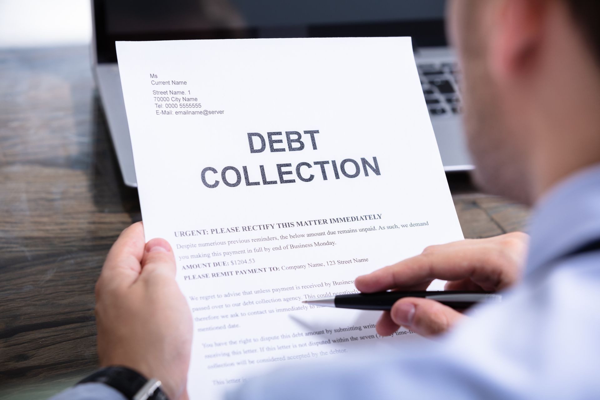 A man is holding a piece of paper that says `` debt collection ''.
