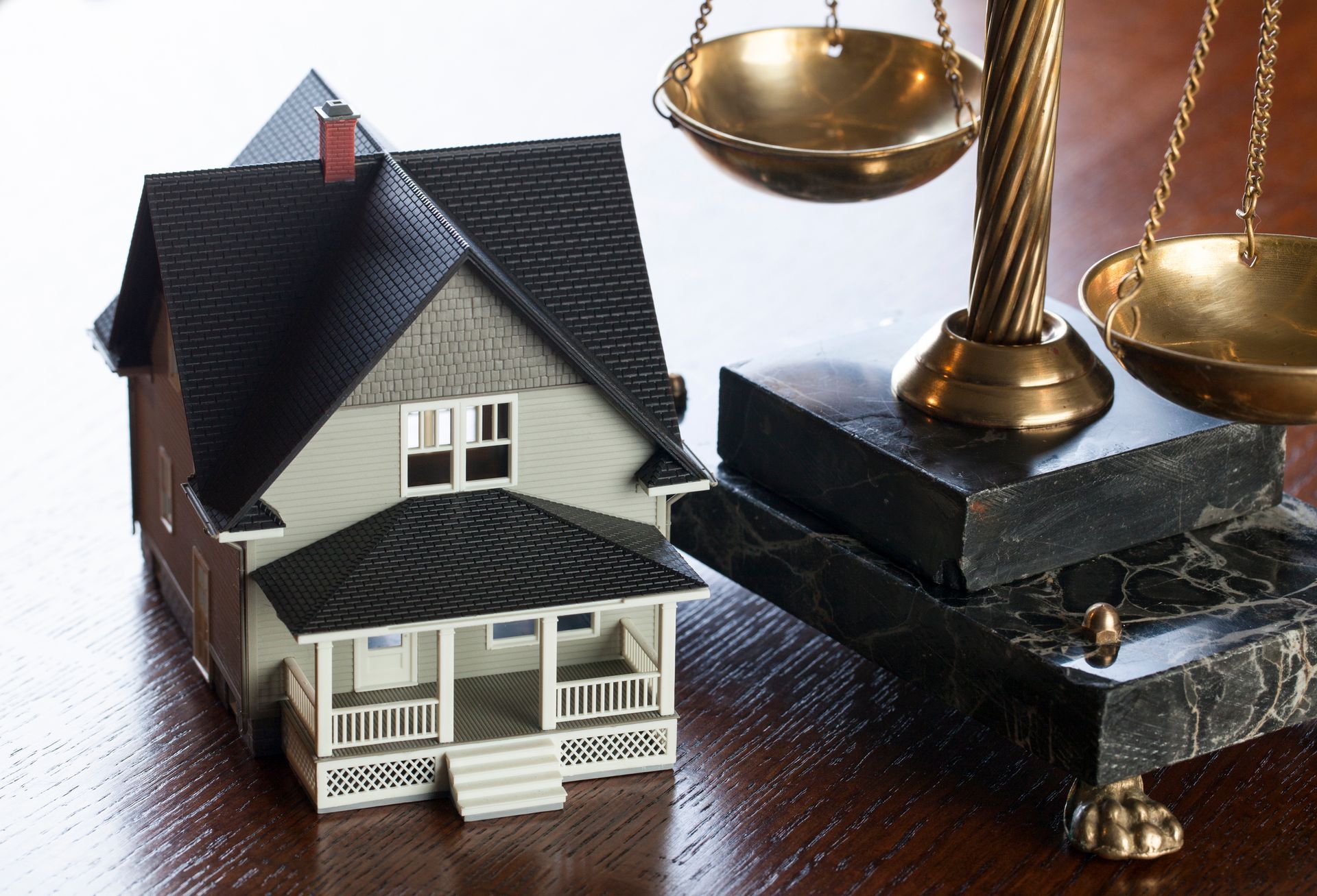 A model house sits next to a scale of justice