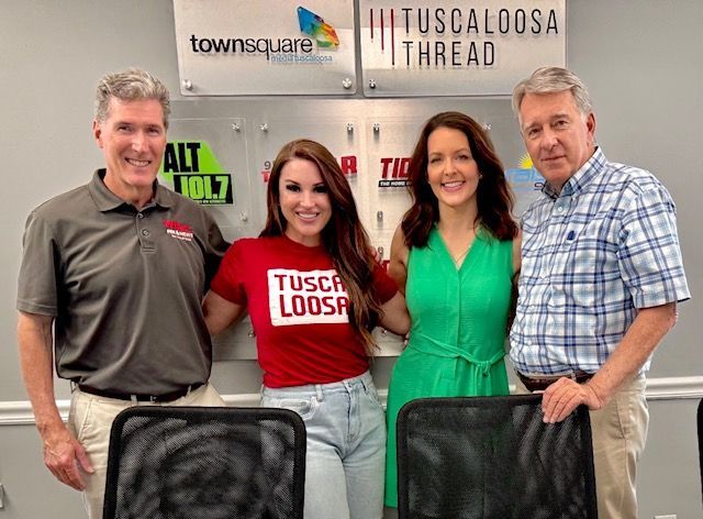 Four people posing in a radio studio, with Townsquare and Tuscaloosa Thread signs behind them.