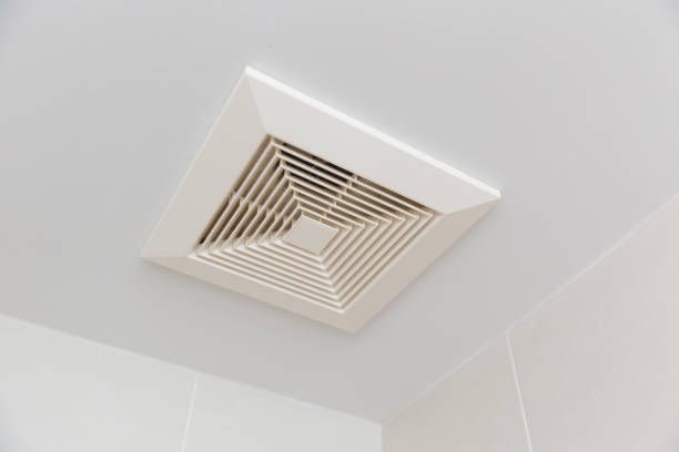 White ceiling-mounted bathroom exhaust fan with square, slatted vent design.