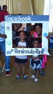 People posing with a Facebook photo frame at Peninsula Park.
