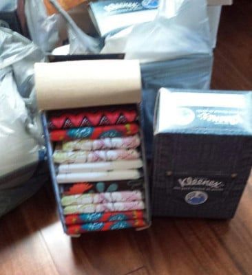 Tissue boxes: One denim Kleenex box and a DIY holder filled with colorful fabric folded as tissues, and a roll of cardboard.