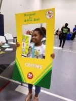 Girl framed by a yellow crayon cutout with 
