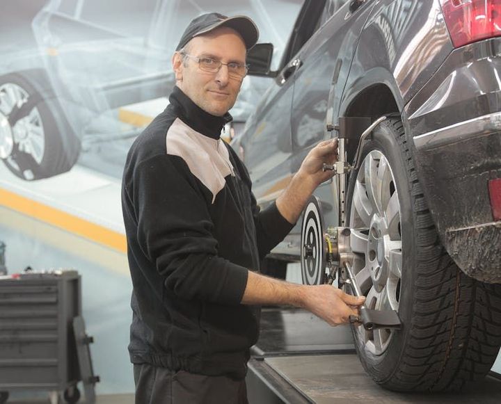 A man is working on a car wheel in a garage