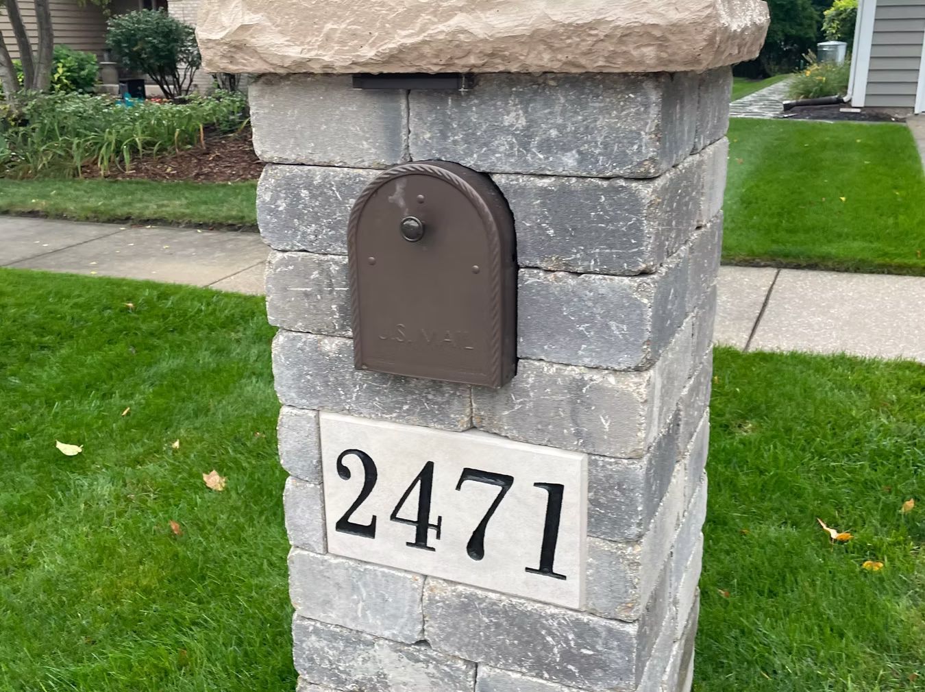 Stone mailbox pillar with brown mailbox and house number 2471