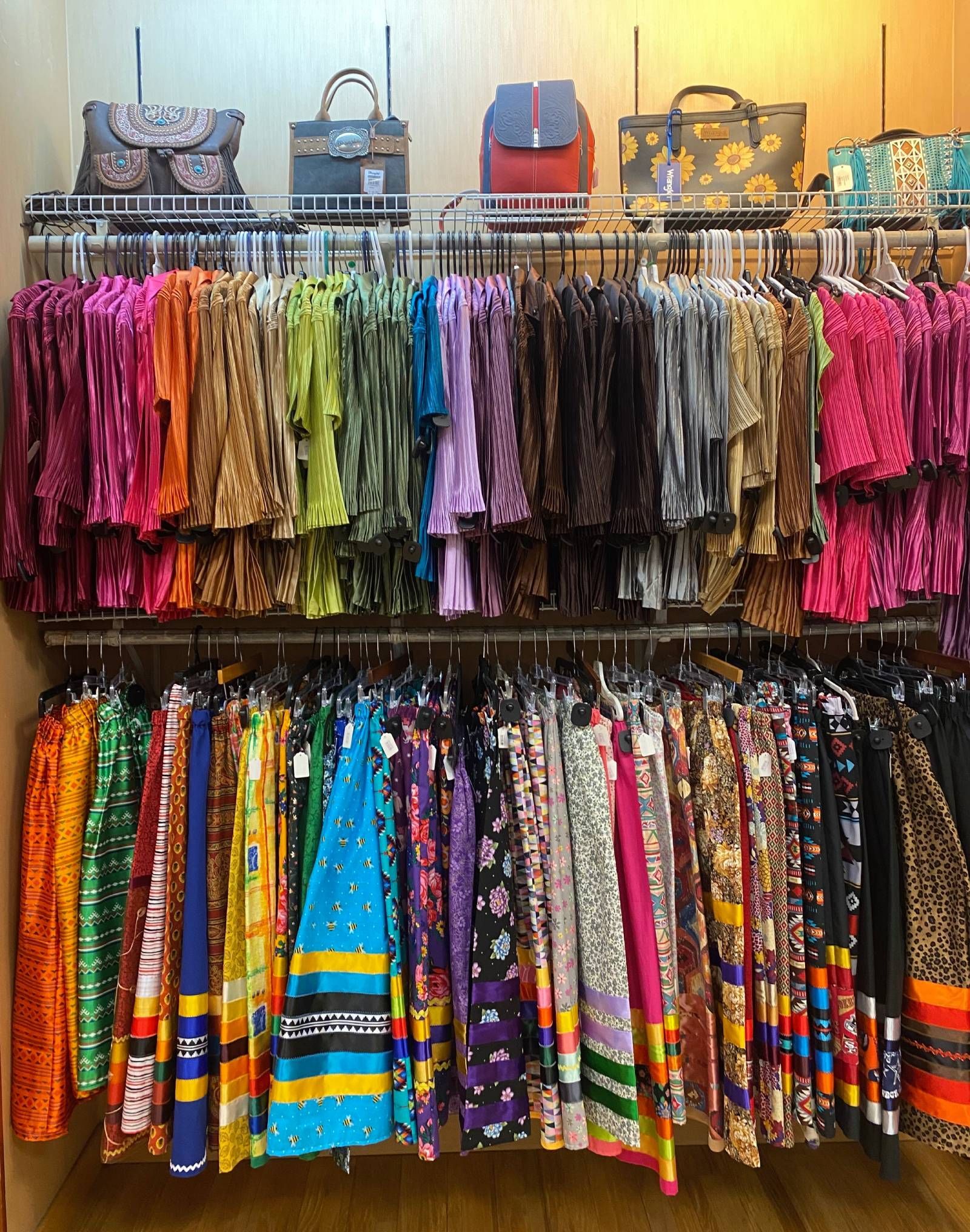 Colorful patterned scarves and handbags displayed on racks in a shop