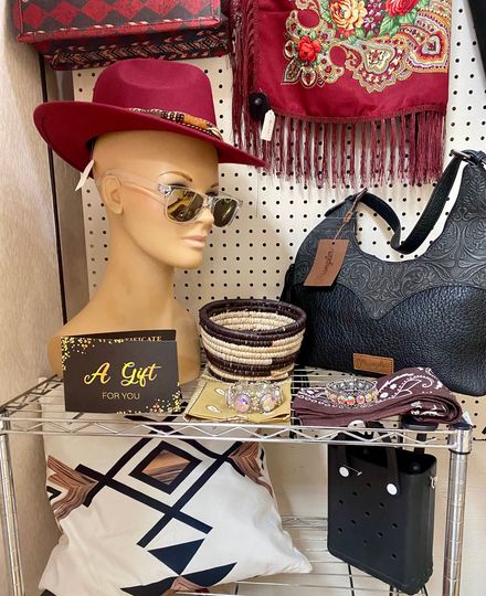 Boutique display with brown handbags, folded jeans, and a denim jacket on mannequins and shelves