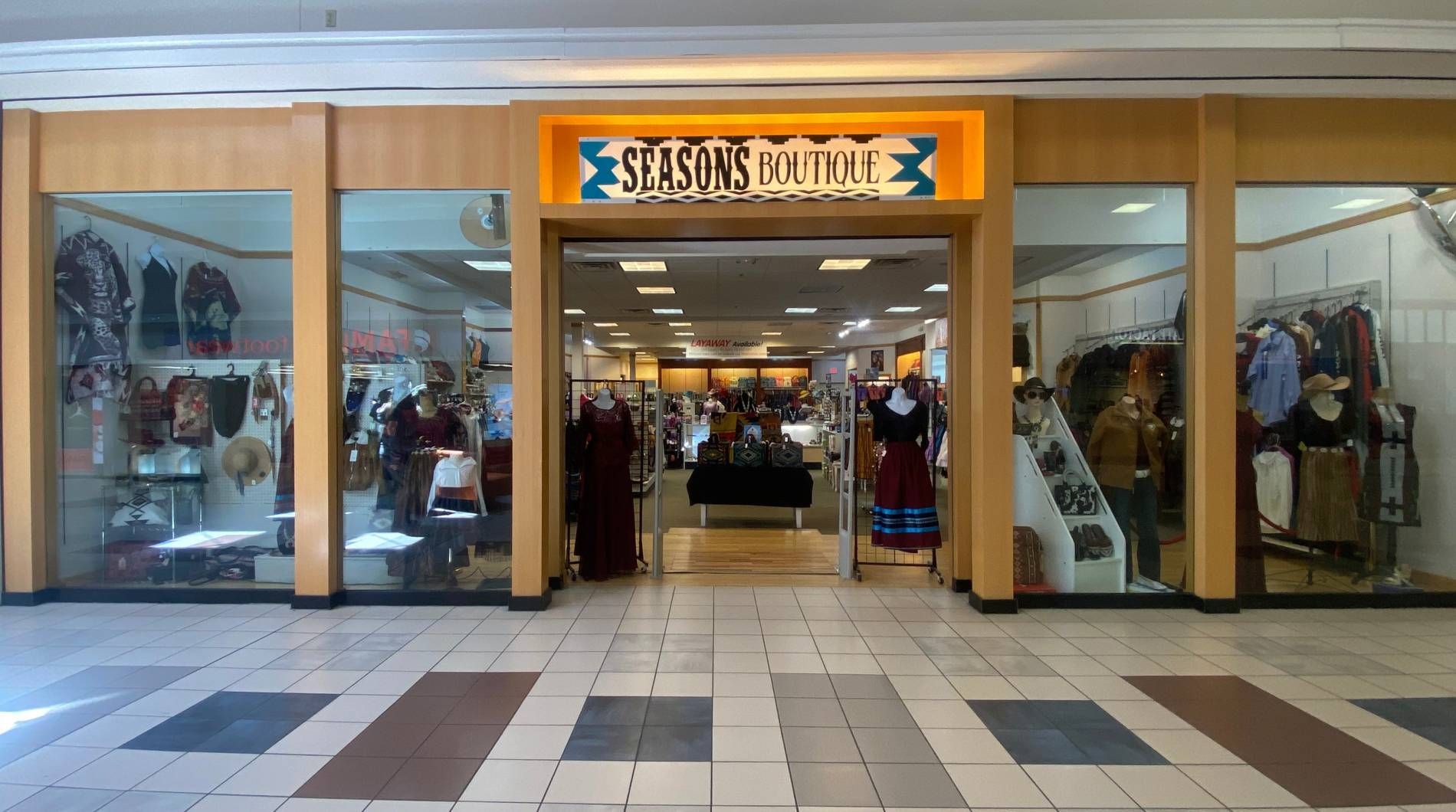 Seasons Boutique display with traditional clothing, moccasins, jewelry, and Wrangler bags