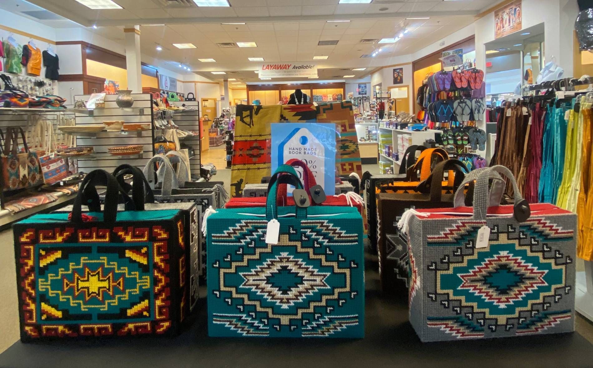 Colorful woven bags displayed on a store shelf in a retail shop