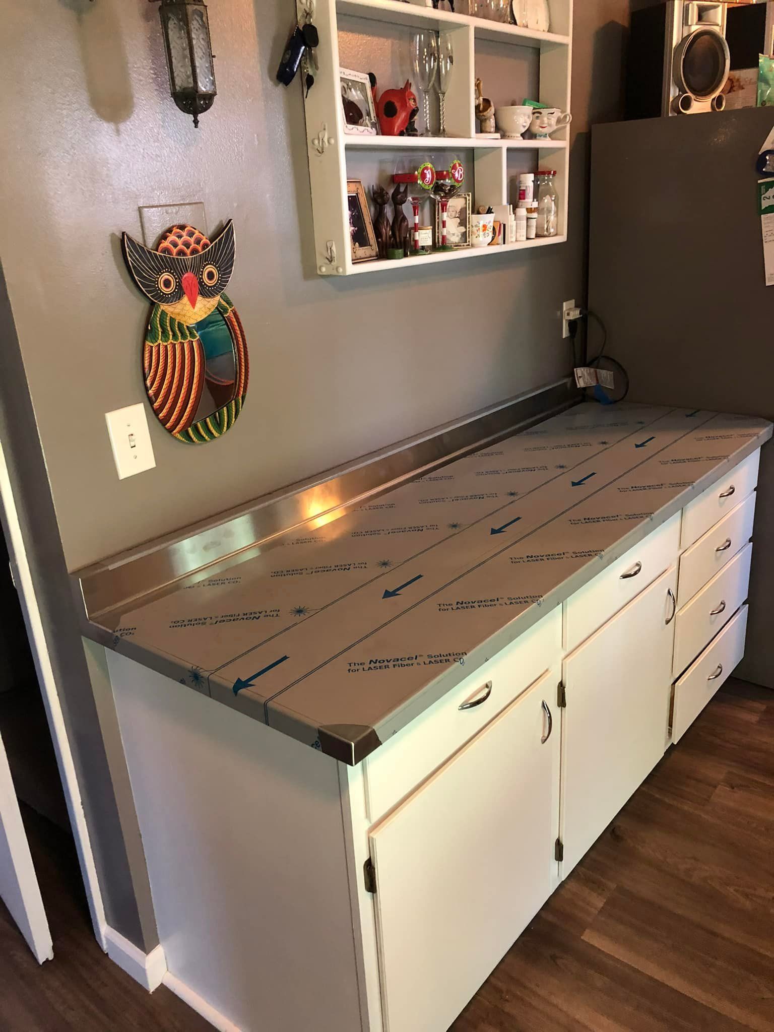 Small craft room with a gray-topped storage cabinet and wall shelves displaying decor