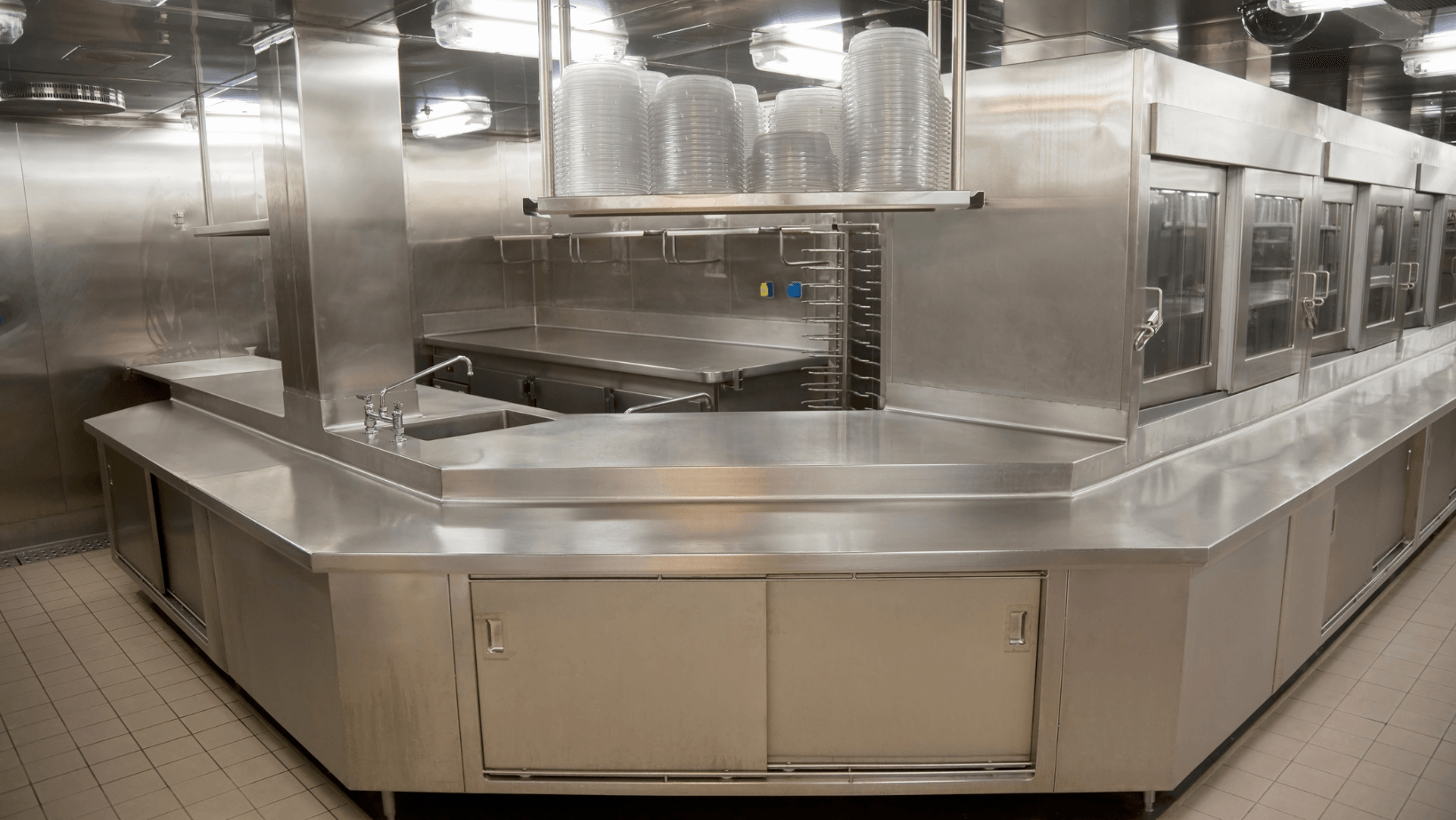 Empty stainless steel cafeteria serving counter in a commercial kitchen