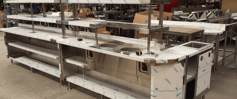 Long warehouse shelves lined with stacked wooden tables and metal frames
