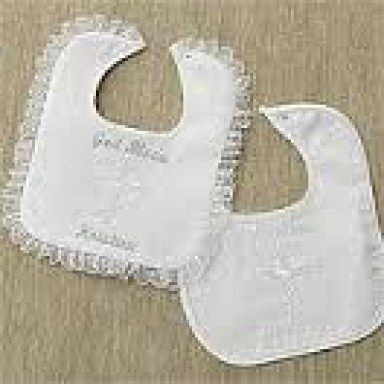 Two white baby bibs on a beige textured background, one plain and one with a ruffled edge