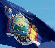 New York state flag waving against a blue sky