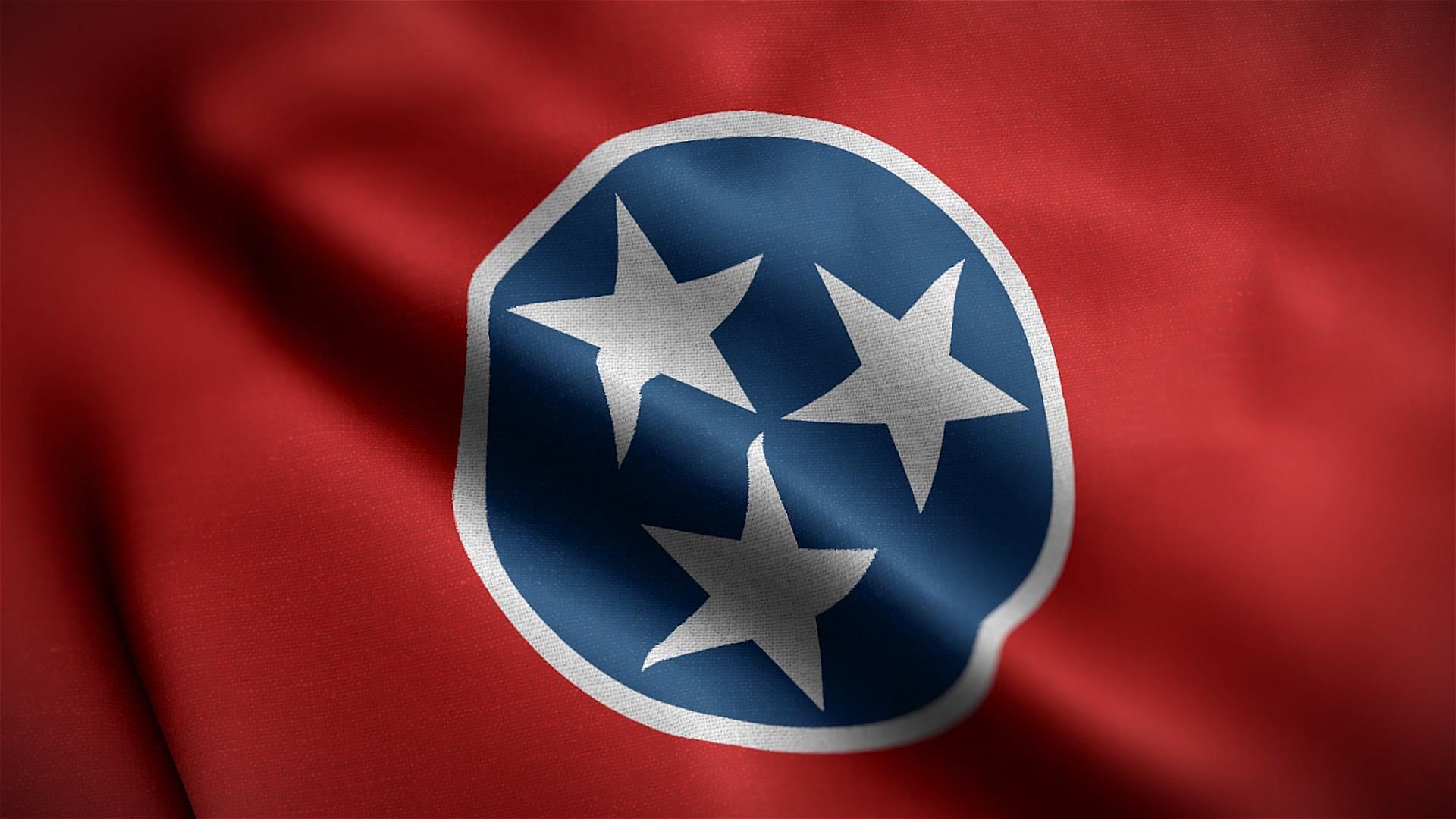Tennessee state flag waving, red field with blue circle and three white stars