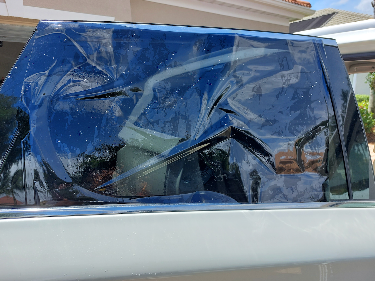 The back window of a truck is wrapped in plastic.