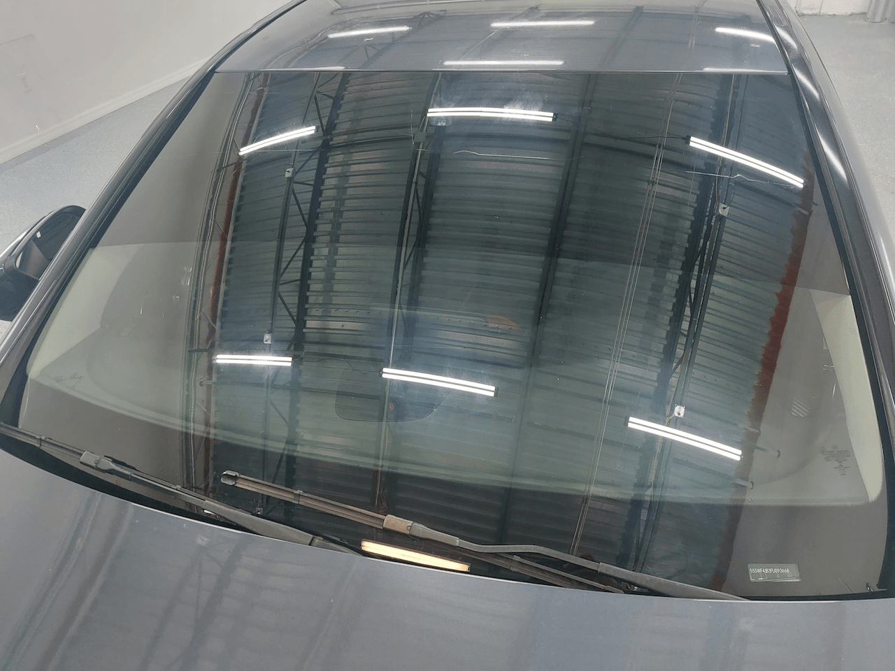 A close up of a car windshield in a warehouse